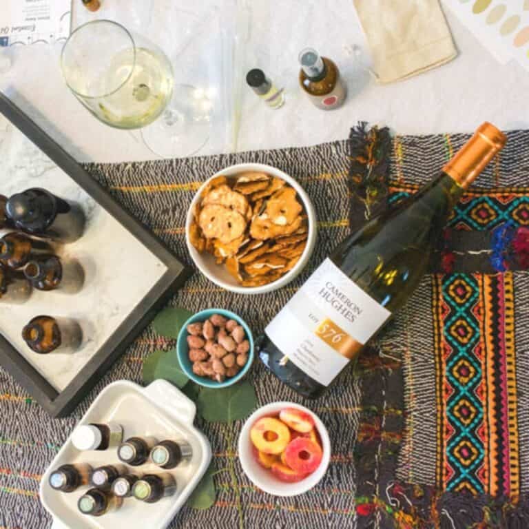 Overhead view of a table with wine and essential oils for a holiday party.