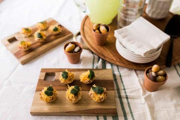 Serving tray on a table set for a football party holding Chicken Taco Cups.