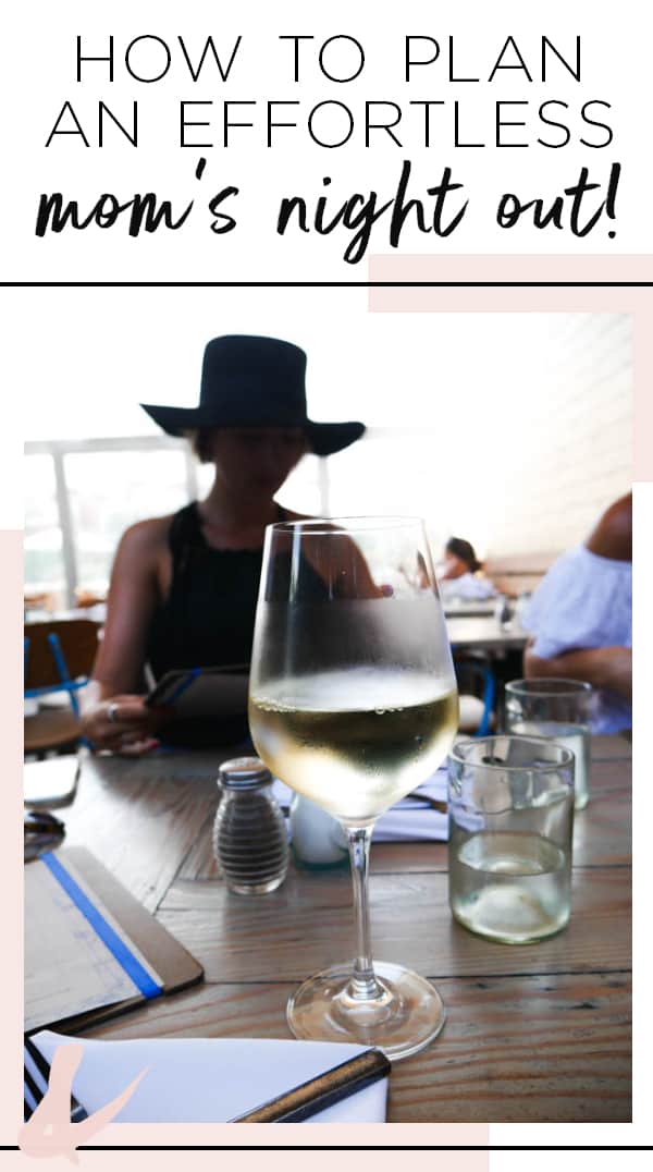 Silhouette of girl at a restaurant table with a wine glass in front of her.