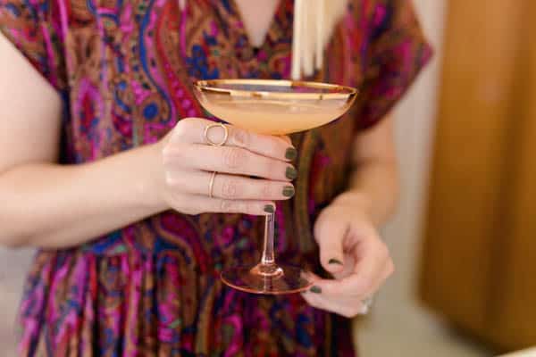 a girl holding a rum based cocktail