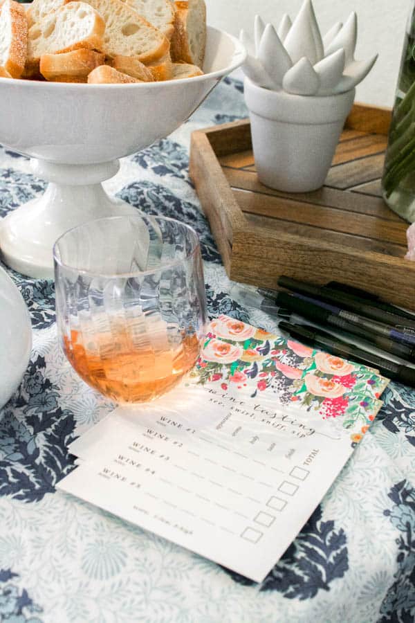 A wine tasting card for taking notes next to a glass of rose.