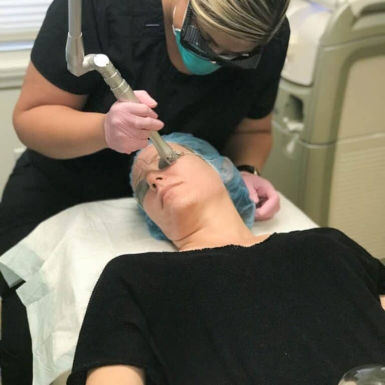 A woman getting a laser treatment on her face.
