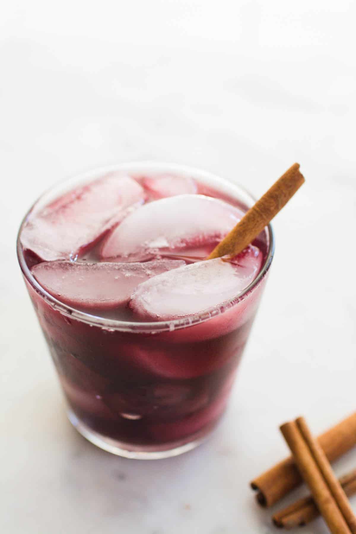 A glass full of iced sangria made with red wine and cooked apples.