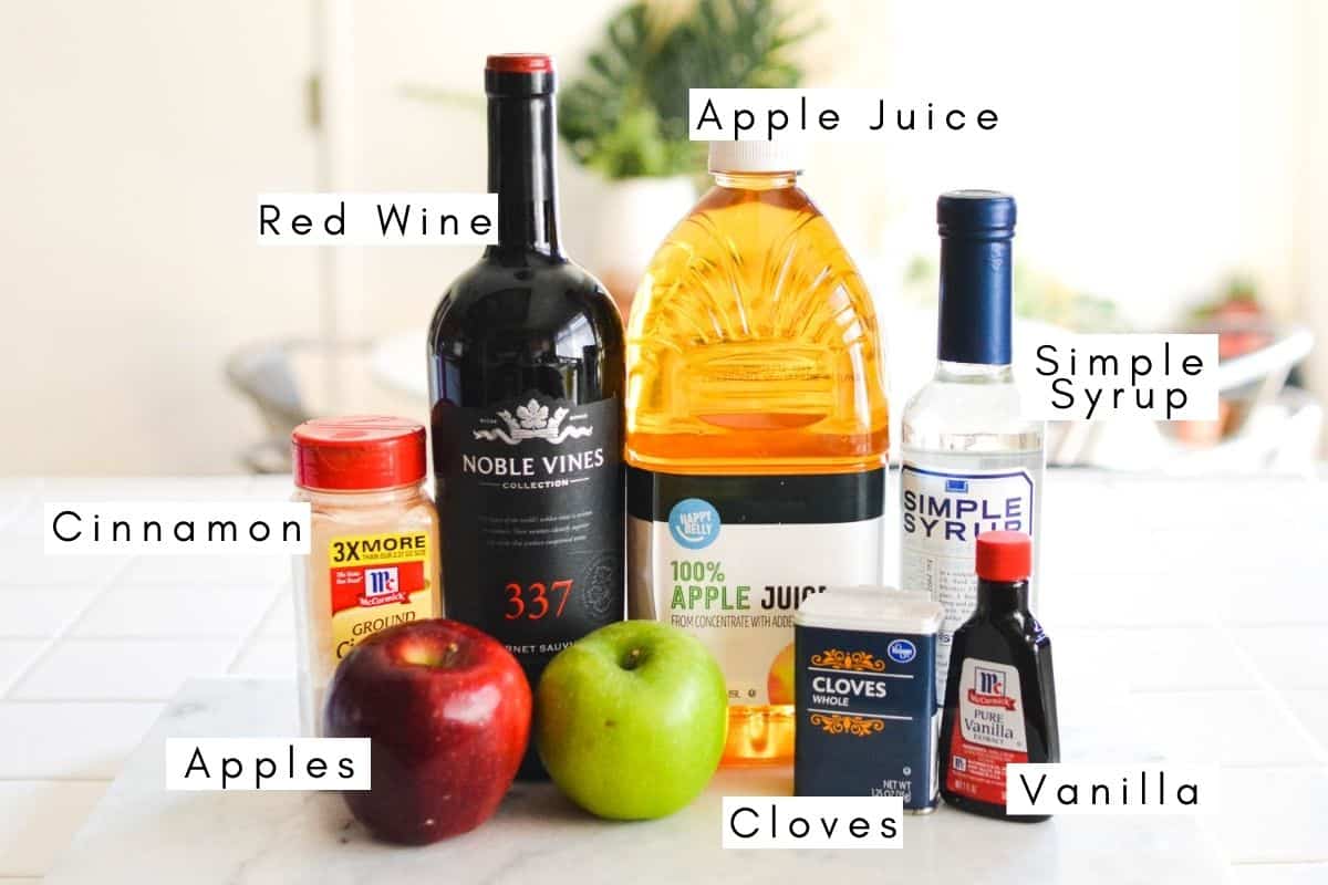 Labeled ingredients for making apple sangria with red wine.
