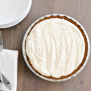 Close up of a frozen peanut butter pie next to some plates and forks.