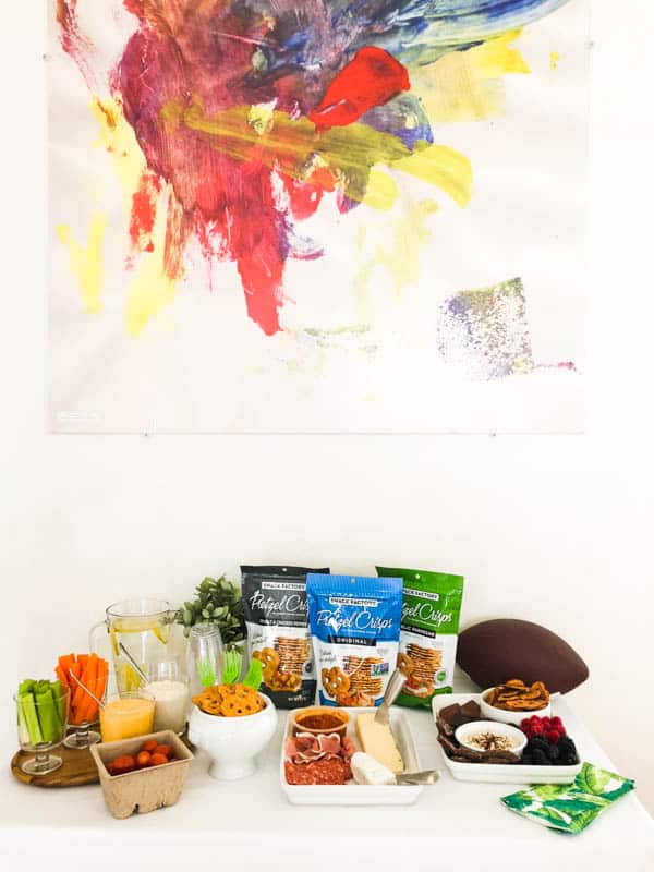 Easy game day snacks on a party food table with bags of Pretzel Crisps.