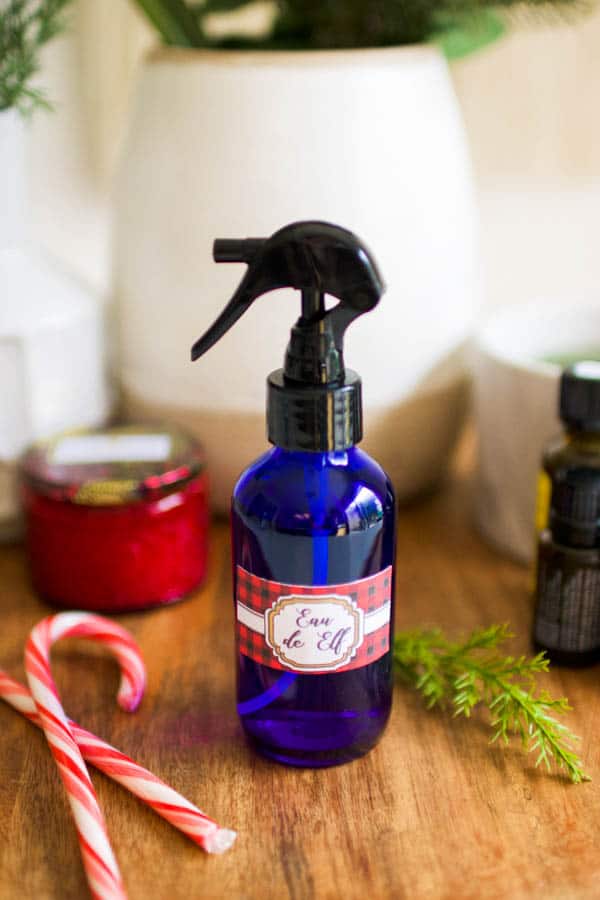 Close up of a blue glass spray bottle with a holiday label on it.