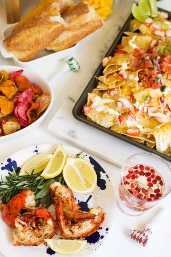 A party table for New Year's Eve with lobster tails, lobser nachos and some chips. 