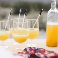 Close up of glasses on an outdoor table full of champagne punch.