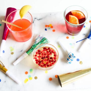 Square, top down image of non alcoholic new year's drinks for kids surrounded by fun party noisemakers.