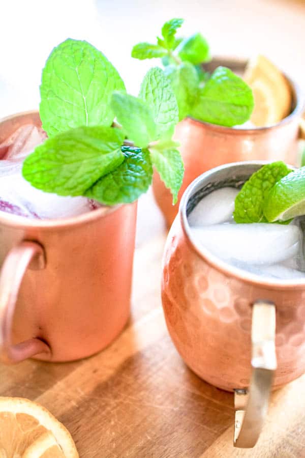 Close up of copper mugs with mint garnishes.