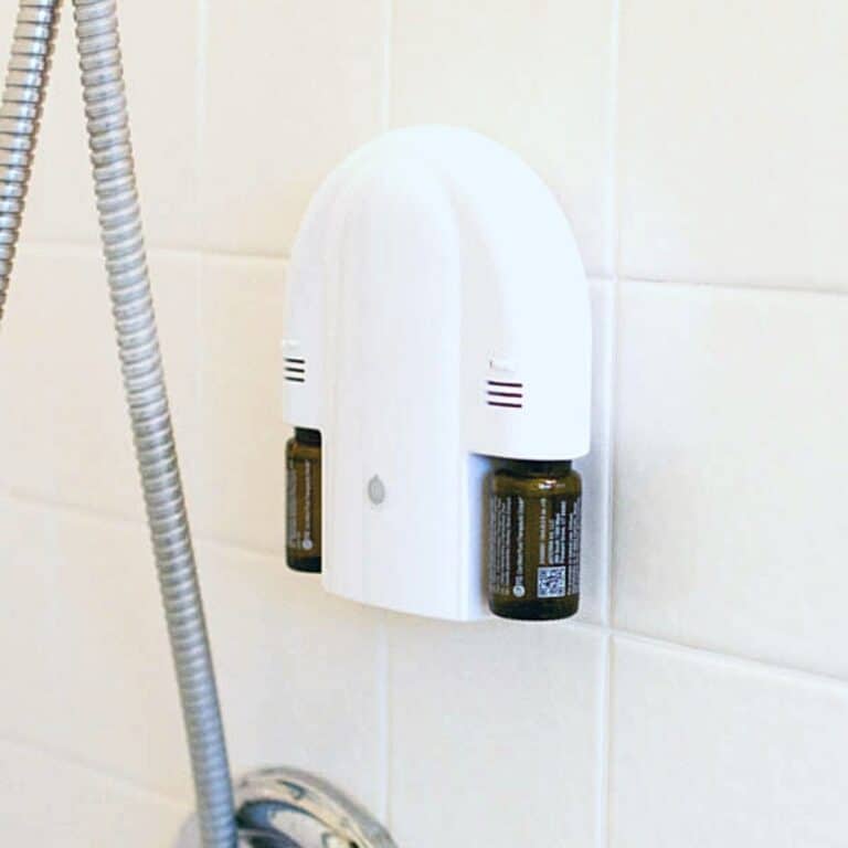 Close up of a shower diffuser stuck on the wall of a shower.