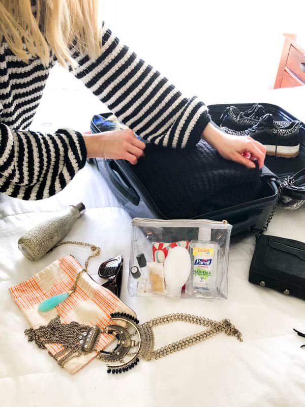 A woman packing a suitcase. 