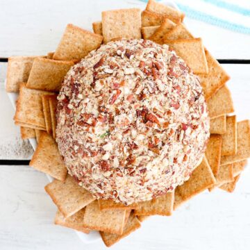 Overhead shot of Chicken Ranch Cheese Ball on a plate with crackers.