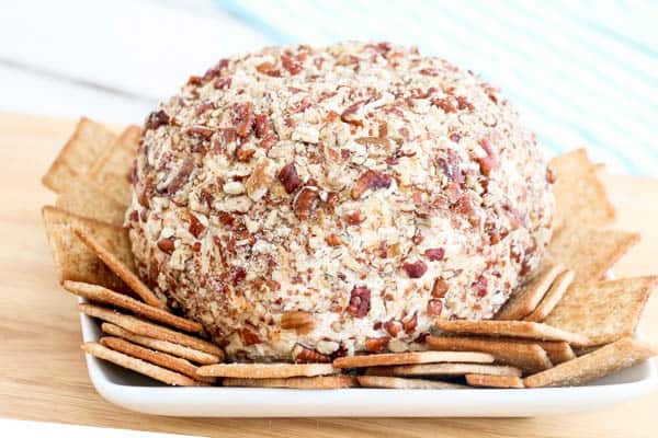 Chicken, ranch and bacon cheese ball on a white plate with crackers.