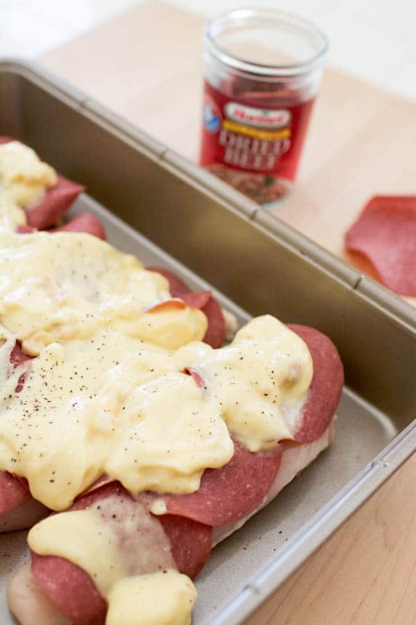 A baking pan with chicken topped with dried beef slices and cream of chicken soup before baking. 