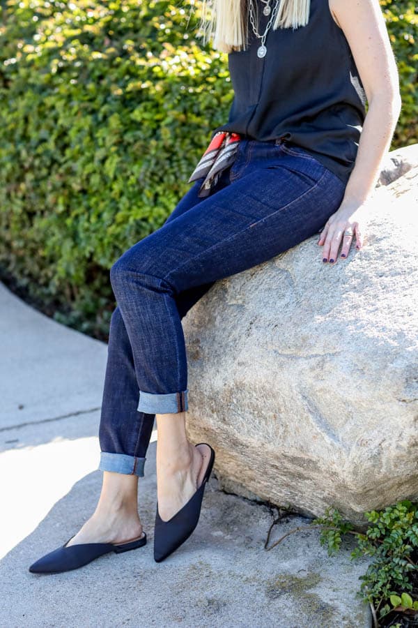 Close up of dark jeans on a women with cuffed hems. 