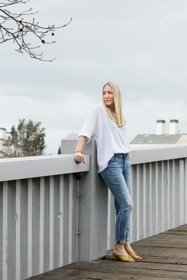 Woman in light jeans with a cute white top on a bridge. 
