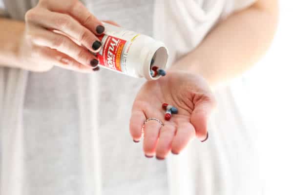 Woman pouring Tylenol into her hand. 