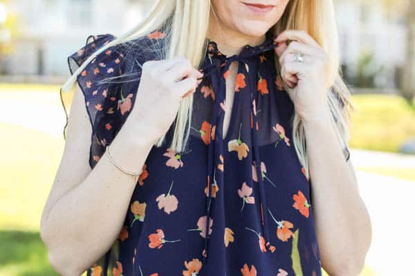 Close up of tie detail on a blue floral blouse. 