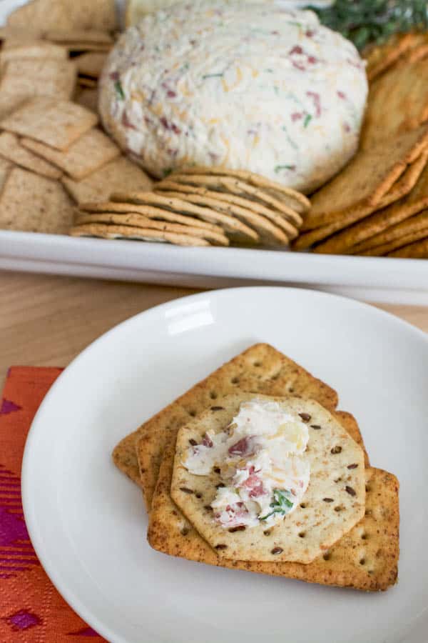 Crackers topped with dried beef cheese ball served on a white plate