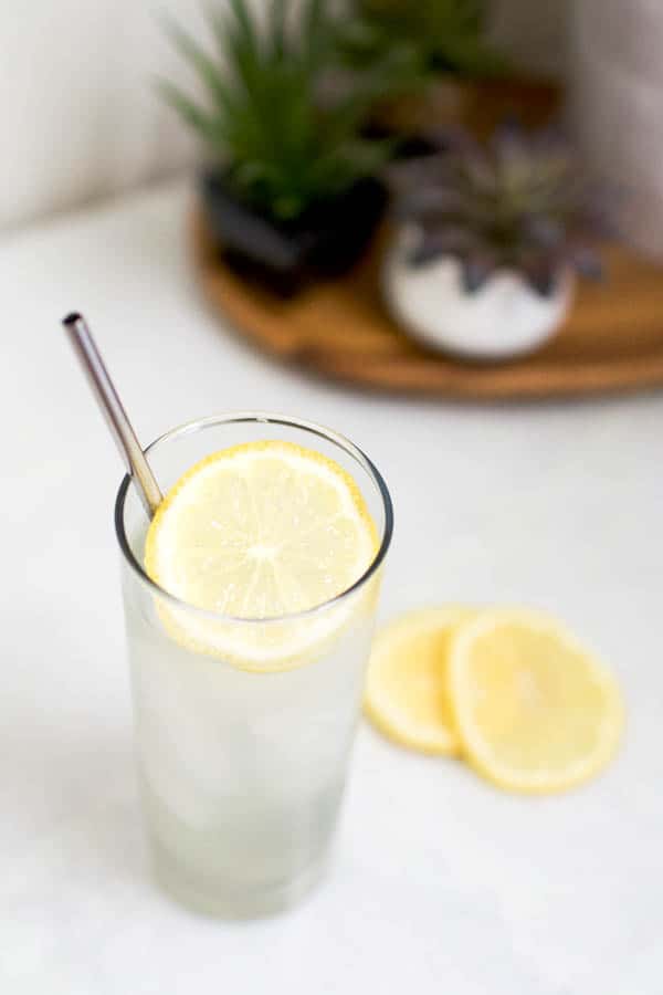 Close up of the lemon garnish in a cocktail with a straw.