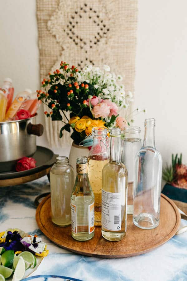 A variety of mixers to make non-alcoholic mimosas on a tray. 