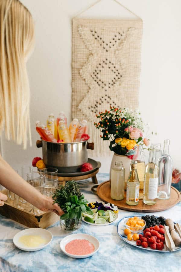 Woman setting down a cup of herbs on a beverage table for a Mother's Day party.