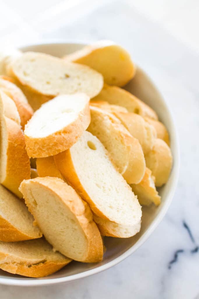 Close up of sliced crostini in a bowl.