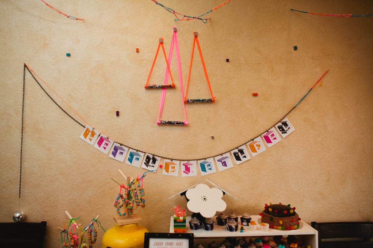 A table with a lego themed happy birthday banner and snacks and treats for a kids birthday party.