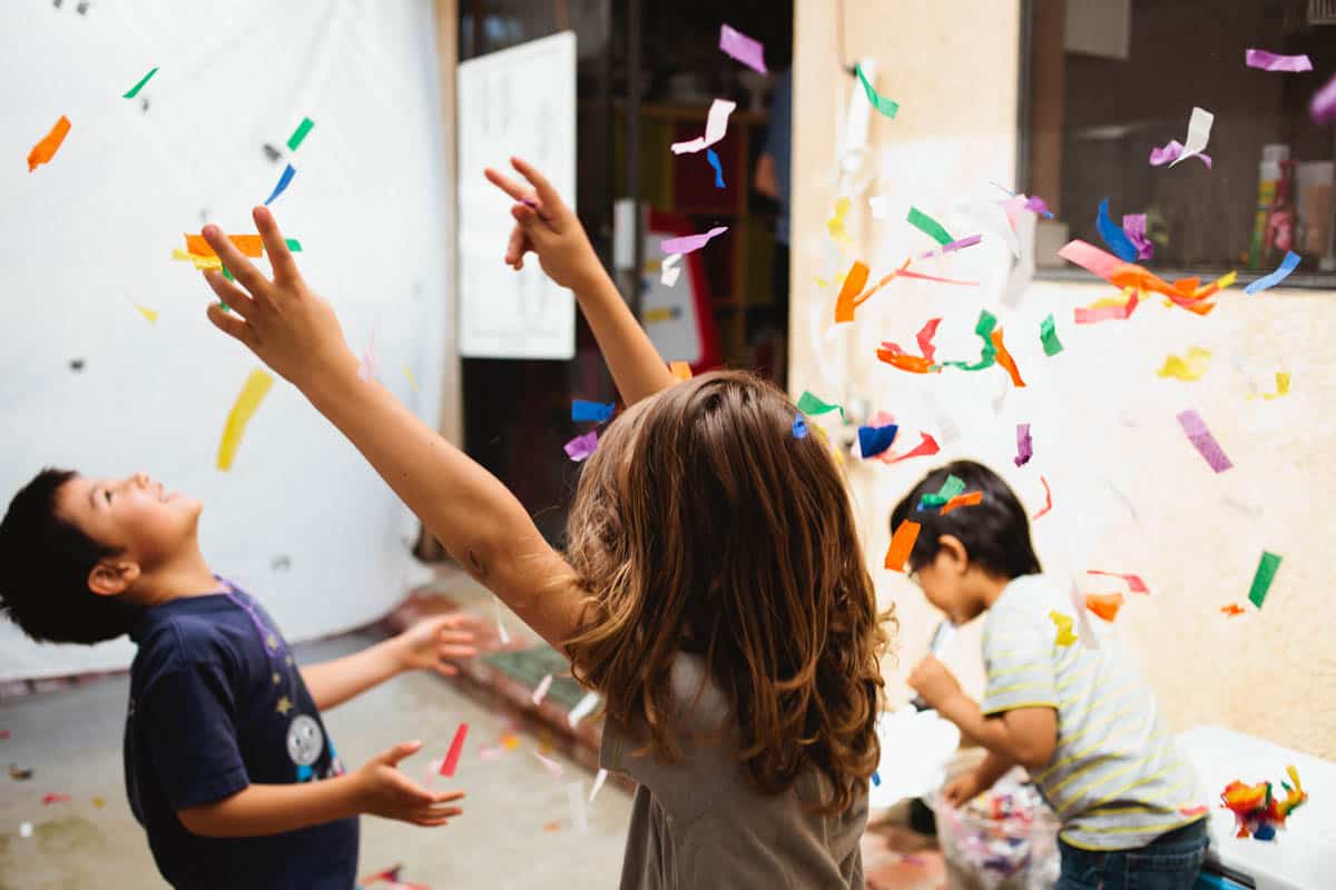 Kids dancing in confetti at a kids birthday party.