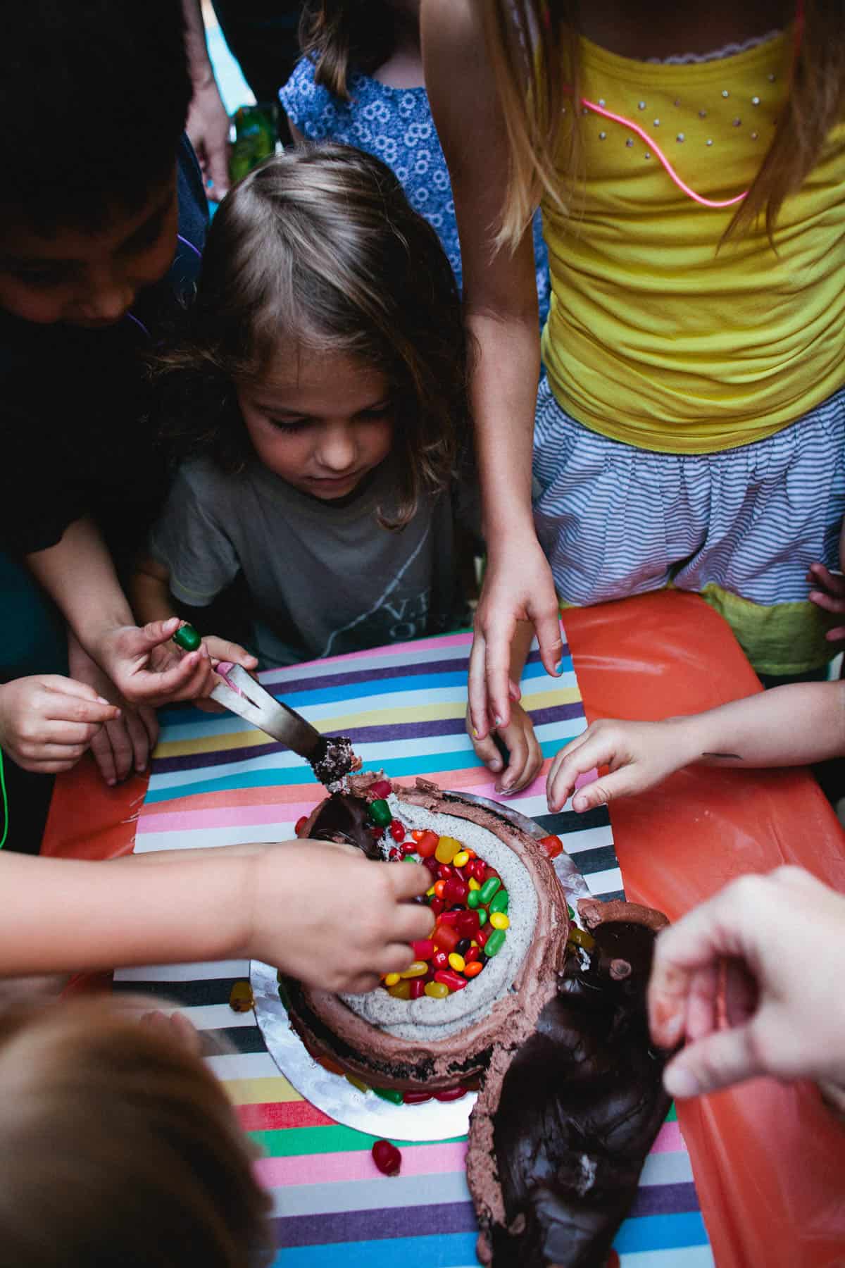 Kids digging into a smash cake at a kids birthday party.