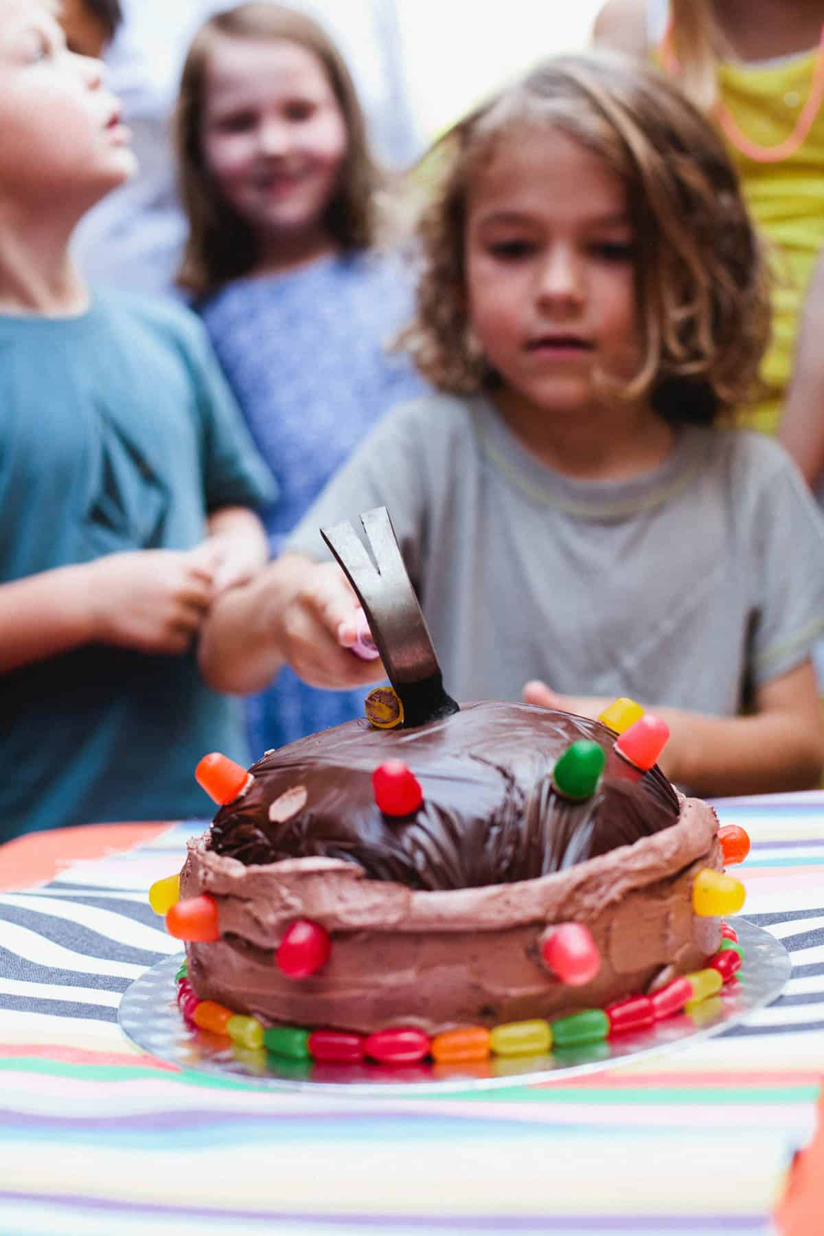 Kid with a lego themed smash cake at a lego birthday party.