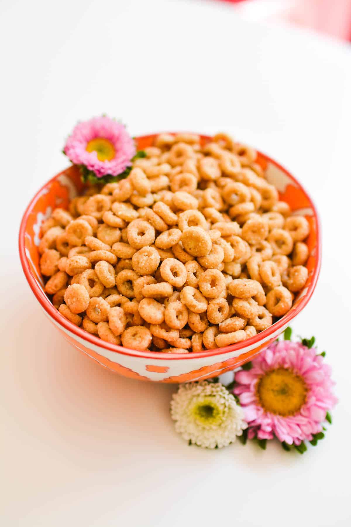 A bowl with Cheerios with flowers around it.