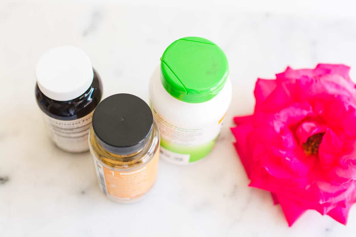 Overhead shots of 3 supplements on a table next to a pink rose.