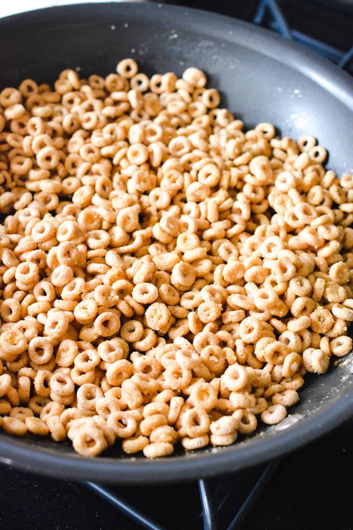 A pan with fried cheerios on the stove.