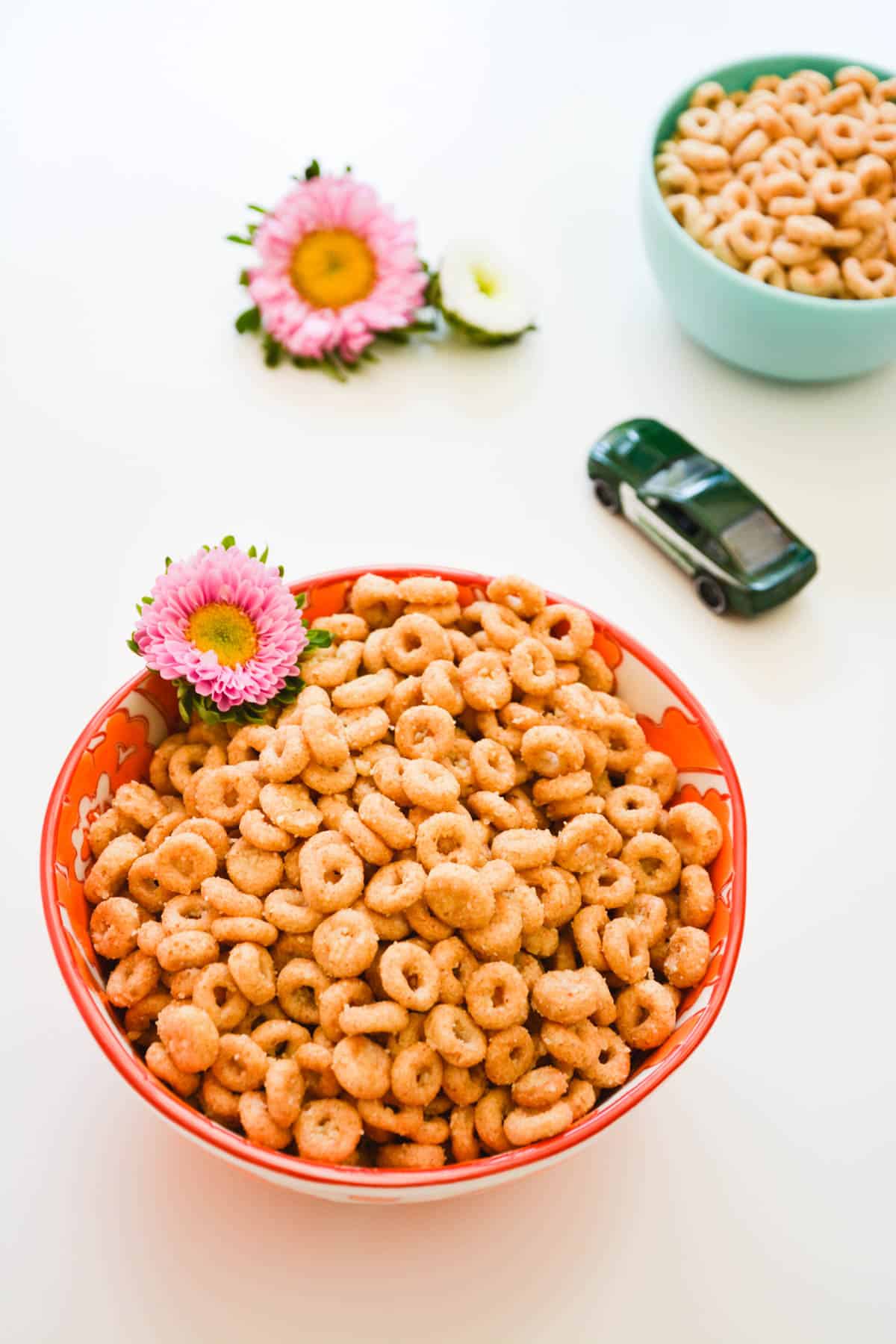 A bowl on a table with Fried Cheerios and a toy car in the background.