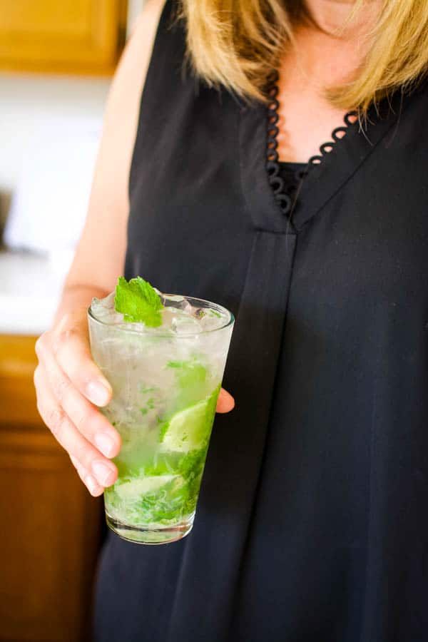 Woman holding a vodka mojito in her hand. 