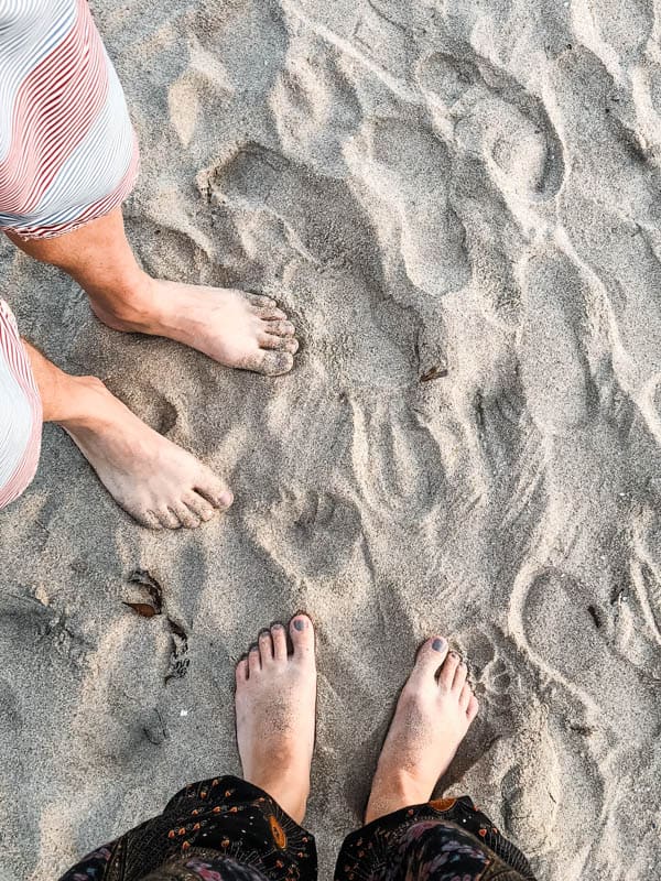 A photo of feet in the sand.