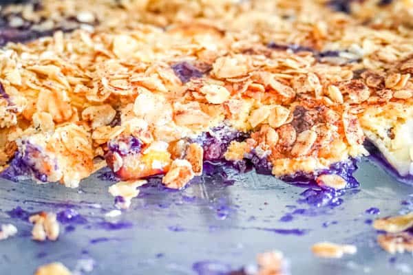 Blueberry dump cake recipe with canned peaches topped with oatmeal and cinnamon.