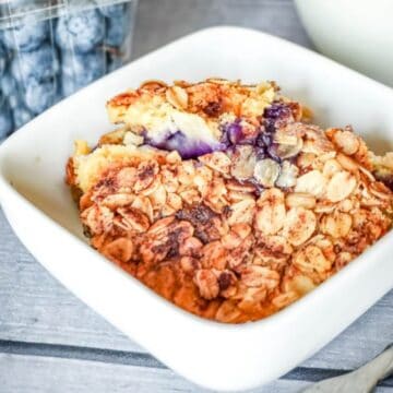 Close up image of peach and blueberry dump cake in a white dish.