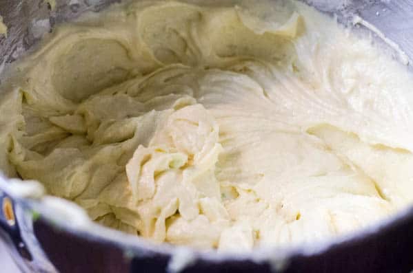 Tequila infused buttercream frosting being made in the bowl of a stand mixer.
