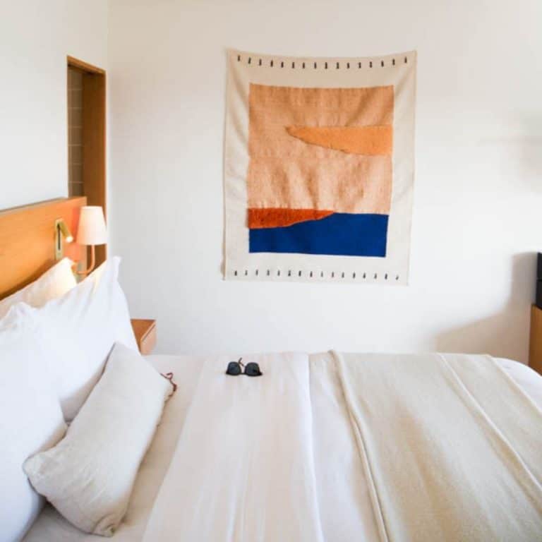 A bed with white bedding at the Hotel Joaquin in Laguna Beach.