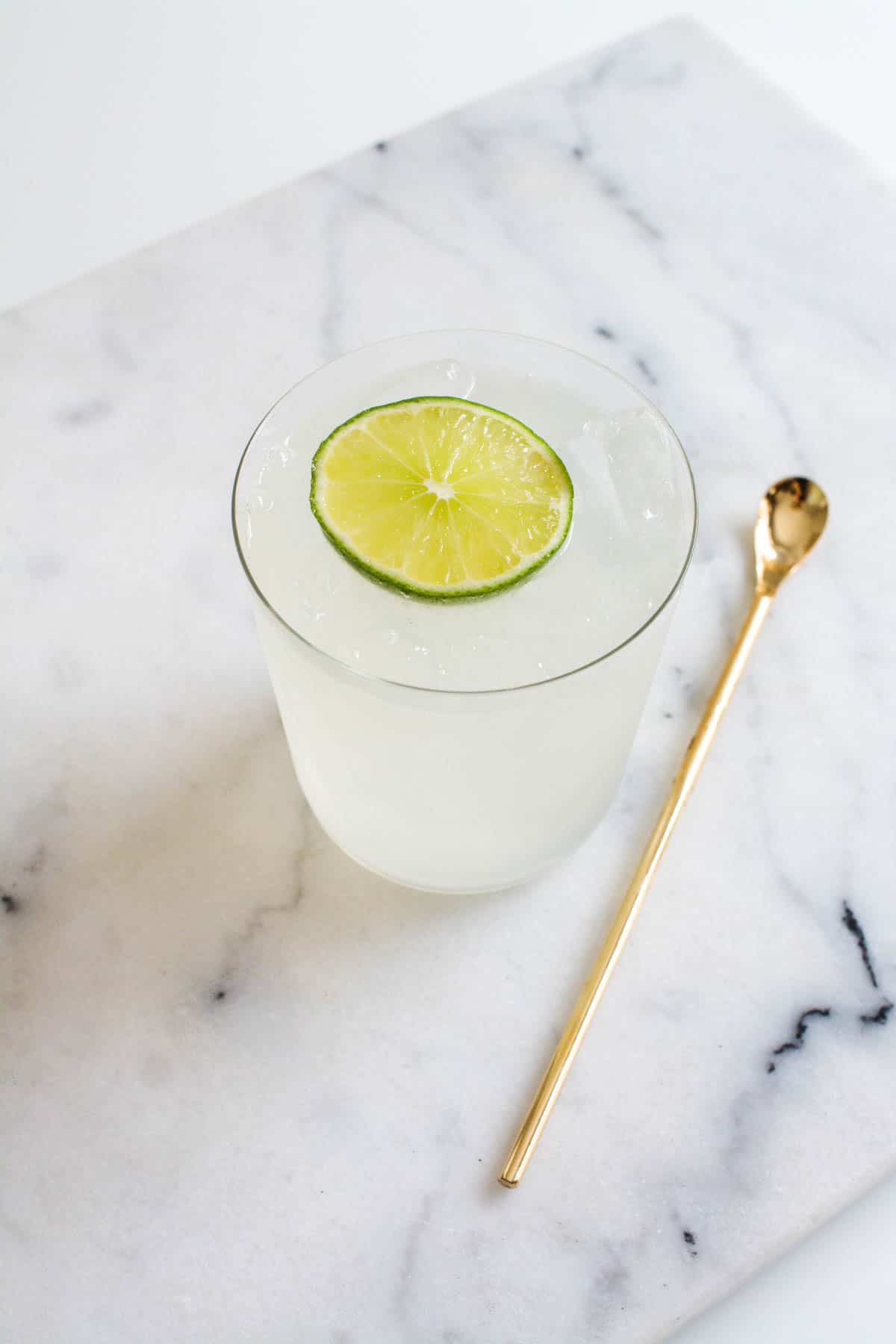 Overhead shot of my casa skinny margarita on a marble cutting board with a bar spoon laying next to it.