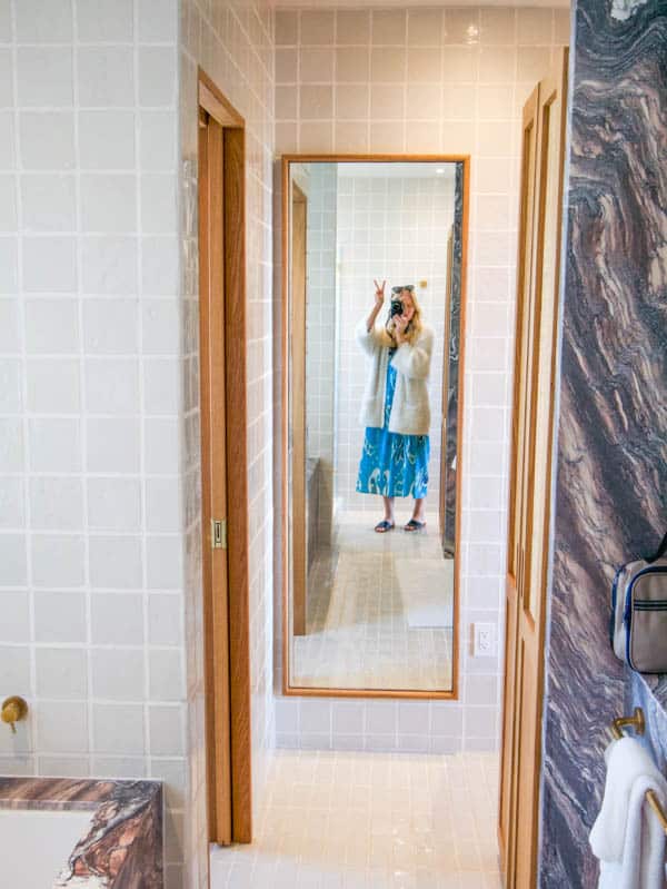 Girl standing in front of a full length mirror on a weekend getaway to a hotel in Laguna Beach.