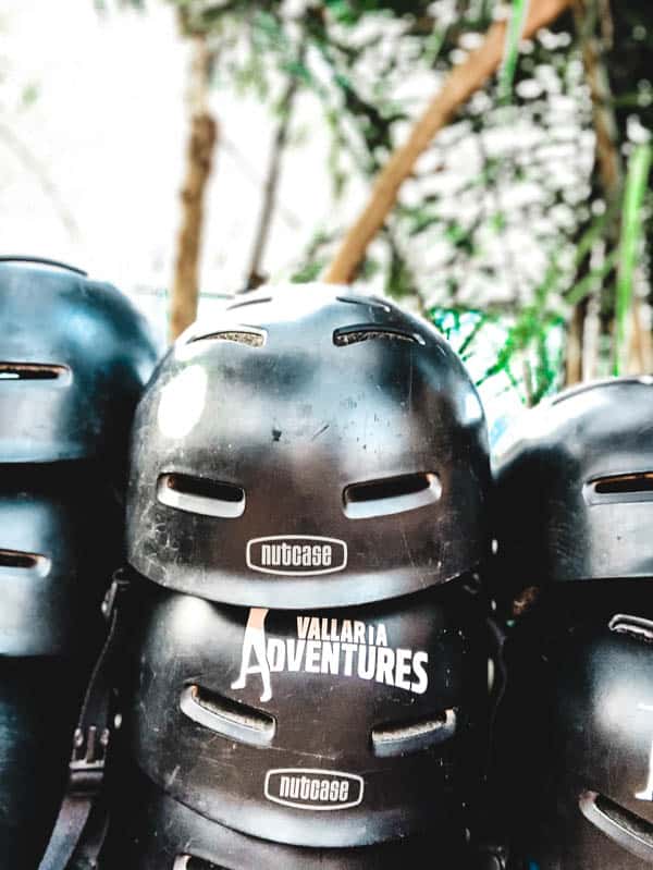 Helmets stacked on a bench that say Vallarta Adventures