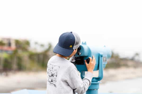 kid looking in telescope on the san clemente pier