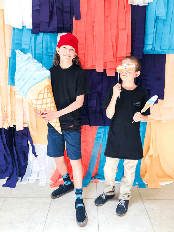 two boys in front of a photo booth back drop