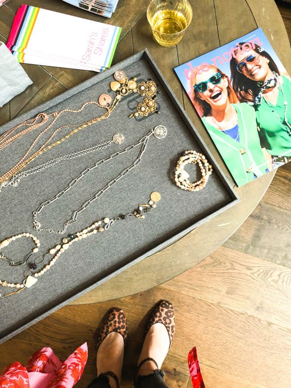 a tray of cabi necklaces laying on a table next to a catalogue.