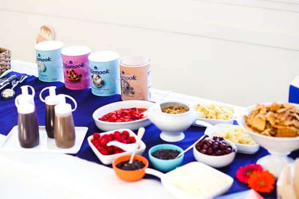 ice cream and sundae toppings set out on a table.